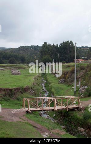 Pont sur la rivière et cascade sur le chemin de l'entrée des ruines. Ruines et mur de pierre à Sacsayhuamán, forteresse Inca à Cusco. Banque D'Images