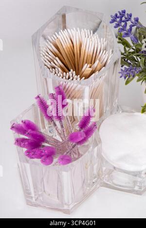 Un gros plan d'un organisateur cosmétique. Tampons de coton et brosses roses pour cils et sourcils Banque D'Images