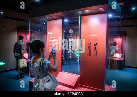 Guangzhou Chine 30 août 2025 : visiteur féminin prenant des photos d'un ensemble de pendentif de jade de Royaume de Han Nanyue occidental, un bel ornement funéraire, affiché dans le Banque D'Images