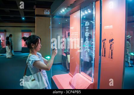 Guangzhou Chine 30 août 2025 : visiteur féminin prenant des photos d'un ensemble de pendentif de jade de Royaume de Han Nanyue occidental, un bel ornement funéraire, affiché dans le Banque D'Images