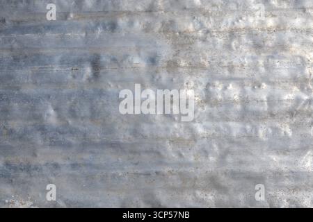 La surface en aluminium grungy affiche une variété de textures, de bosses et de rayures sous la lumière du jour. L'aspect altéré évoque une sensation industrielle Banque D'Images