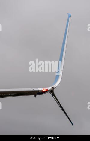 Une ailette sur un jet de passager contre un ciel nuageux. La pointe de l'aile d'un avion. Une lumière rouge sur le bout de l'aile d'un avion. Banque D'Images