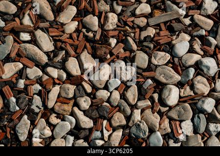 Texture en gros plan de galets blancs mélangés et de copeaux de bois bruns, idéale pour le jardinage, l'aménagement paysager, les fonds naturels et les concepts de design respectueux de l'environnement. Banque D'Images