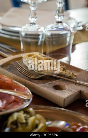 Casu Marzu, fromage sarde avec larves de Piophila casei, servi sur une table sarde traditionnelle. Banque D'Images
