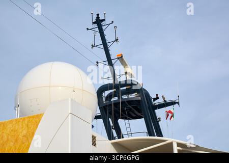 Le réseau sophistiqué de capteurs, d'antennes et d'un dôme satellite sur un navire symbolise la connectivité mondiale, la sécurité maritime et la navigation avancée Banque D'Images