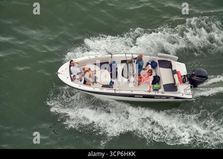 Venise. Italie - 24 septembre 2025 : une vue aérienne de haut en bas capture un groupe de personnes et un petit chien en train de se détendre sur un hors-bord alors qu'il traverse le Banque D'Images