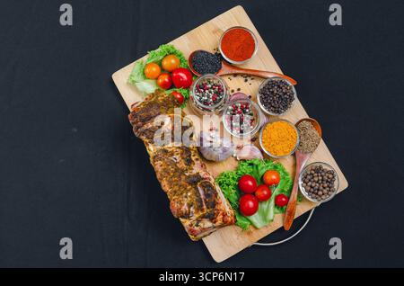 Ensemble de délicieux bacon et épices brillantes de curcuma, paprika, poivrons divers, sésame, cumin, clous de girofle et légumes, y compris tomates cerises, ail Banque D'Images