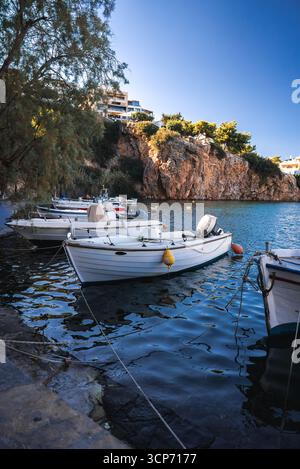 Bateaux de pêche amarrés le long d'une crique Turquoise en Crète, Grèce Banque D'Images