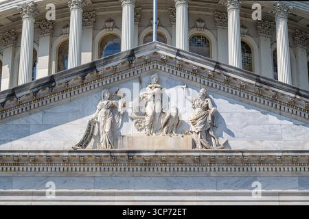 Sculpture du fronton du bâtiment du Capitole DES ÉTATS-UNIS Washington DC // WASHINGTON DC — la sculpture du fronton sur le front est du bâtiment du Capitole des États-Unis présente des figures allégoriques représentant les concepts de la démocratie et du progrès américains. La sculpture en marbre représente Justice Holding Scales, une figure représentant la Constitution, et une autre figure symbolisant la force maritime de la nation avec une ancre. Cette œuvre détaillée, sculptée par Luigi Persico, a été achevée en 1863. Le Capitole des États-Unis, situé à Washington D.C. est le lieu de rencontre du Congrès des États-Unis. Banque D'Images