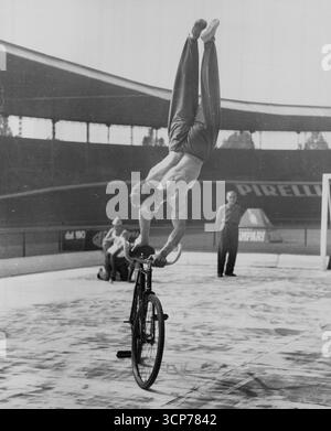 Se déplacer par cycles - « regarde, ma, pas de pieds ! » Le cycliste yougoslave Stanislav Vakulic fait une variante de la routine du no Hands lors des derniers championnats du monde de cyclisme qui se sont tenus près de Rome. Il travaille à un bon rythme, puis se tient sur le guidon et se repose sur ses mains. 23 septembre 1955. (Photo de United Press). Banque D'Images