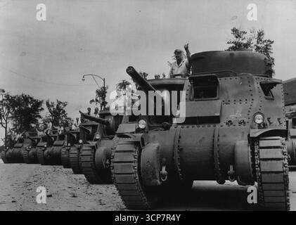 Les chars M-3 américains prêts pour les essais - les pilotes d'essai donnent le signal familier de la victoire alors qu'ils se préparent à mettre de gros chars M-3 de 28 tonnes-appelés 'General Grants' par les Britanniques, qui les ont utilisés avec un succès marqué en Libye - à travers leurs essais à l'usine Chrysler de Detroit, le cœur de l'industrie américaine. 14 septembre 1942. (Photo d'Interphoto News Pictures, Inc.). Banque D'Images