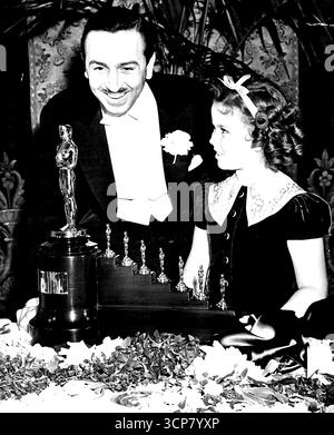 Shirley Temple remet le Special Academy Award à Disney - Shirley Temple, jeune star de l'écran, lors de la fête annuelle de la Motion Picture Academy of Arts and Sciences, remet à Walt Disney le prix spécial de l'Académie pour son "Blanche-neige et les sept nains", qui est reconnu par l'industrie comme une innovation à l'écran qui a été le pionnier d'un nouveau domaine du divertissement. De longs applaudissements ont salué Miss Temple quand elle a marché à la tribune pour faire la présentation à la fête tenue à l'hôtel Biltmore ici. 26 février 1939. (Photo de Wide World photo). Banque D'Images