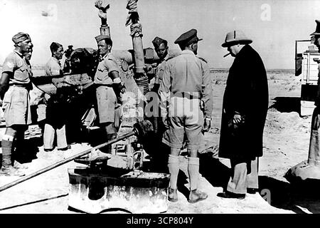 La visite du premier ministre au Moyen-Orient -- M. Churchill dans le désert occidental. M. Churchill visite un site d'armes à feu dans le désert. Au cours de son séjour au Moyen-Orient, M. Churchill a effectué une visite dans la région d'Alamein. Le Premier ministre rencontre des commandants de brigade et de division, visite d'un site d'armes à feu et inspection du personnel des divisions australienne et sud-africaine. 20 août 1942. (Photo par British Official Photograph) Banque D'Images