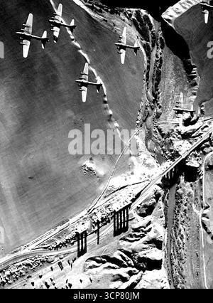 Forteresses de vol américaines survolez les ruines romaines anciennes pour Blast installation allemande en Italie - forteresses de vol de l'aile de l'armée de l'air américaine de 15th sur les restes d'un ancien aqueduc romain sur leur chemin pour bombarder les installations allemandes en Italie, Comme plus de 2 000 ans piliers de l'ancien système d'eau / jeter leurs ombres sur le paysage italien. 16 avril 1944. Banque D'Images