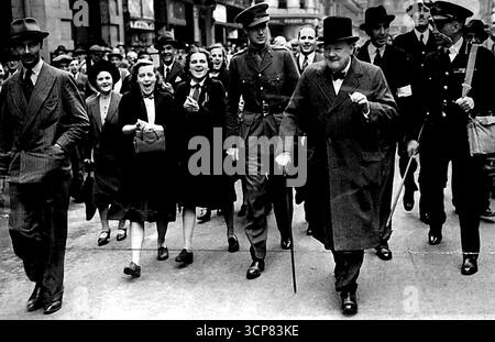 Le premier ministre inspecte -- les filles dans les gens surpeuplés ont suivi M. Churchill pour lui donner un encouragement. Des foules immenses ont suivi M. Winston Churchill aujourd'hui lorsqu'il a inspecté les dégâts et les cratères de bombes causés par les raids de la nuit dernière. M. Churchill a demandé aux gens bondés s'ils étaient découragé et des cris de «non» ont été entendus de tous. 10 septembre 1940. (Photo de Fox photos). Banque D'Images