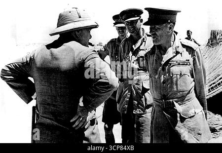 La visite du premier ministre au Moyen-Orient -- M. Churchill dans le désert occidental. M. Churchill discutant avec le C-in-C et les officiers d'état-major après qu'il ait terminé une partie de sa tournée. Au cours de son séjour au Moyen-Orient, M. Churchill a effectué une visite dans la région d'Alamein, la brigade de rencontre du Premier ministre et les commandants divisionnaires, visité un site d'armes à feu et inspectant le personnel des divisions australienne et sud-africaine. 06 octobre 1942. (Photo par British Official photo). Banque D'Images