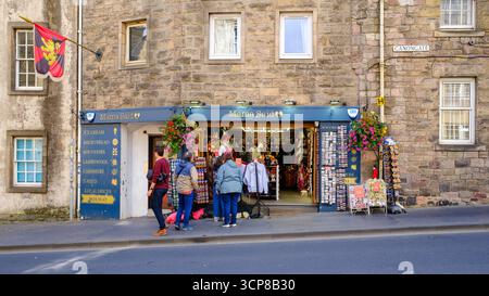 Touristes à l'extérieur de Mama Said, une boutique de tartan et de souvenirs sur le Canongate, Royal Mile, Édimbourg, Écosse. Banque D'Images