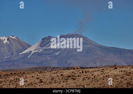 Vivant avec puissance et mystère, le volcan Sabancaya envoie ses panaches vers le ciel - une force dramatique au cœur des Andes Banque D'Images