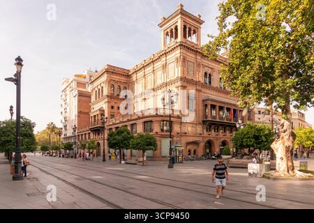 Séville, Espagne - 7 septembre 2023 : le Palacio historique de la Condesa de Lebrija encadre un boulevard sévillan animé avec des voies de tramway, des piétons et des trs Banque D'Images