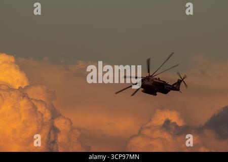 San Diego, Californie, États-Unis - 18 septembre 2025 : le corps des Marines des États-Unis Sikorsky CH-53E Super Stallion Banks au-dessus des nuages du coucher du soleil lors d'un vol en soirée. Banque D'Images