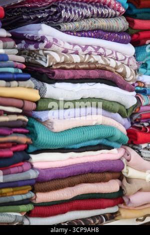 Tissus empilés colorés dans un présentoir de marché Banque D'Images