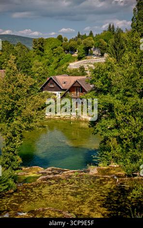 Des maisons en bois traditionnelles et des moulins à eau bordent les rivières et les cascades de Rastoke, un village historique connu sous le nom de « petit Plitvice ». Banque D'Images