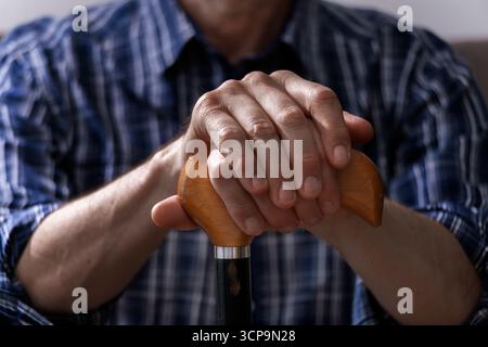 Les mains de l'homme caucasien d'âge moyen tiennent la canne en gros plan Banque D'Images