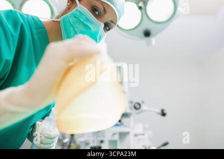 Anesthésiste féminin dans les gommages sarcelle ventilant manuellement avec masque et sac dans OU, copier l'espace Banque D'Images