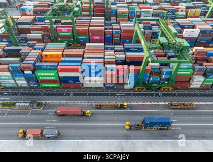 Singapour, Singapour - 06 décembre 2024 : vue aérienne des conteneurs du terminal Pasir Panjang, une symphonie de rouge, bleu et vert, empilés haut, en attente de leur voyage à travers les mers. Banque D'Images