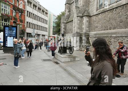Dublin, Irlande - 19 septembre 2025 - les touristes avec leur téléphone portable prennent des photos de la statue de Molly Malone sur Saint Andrew's Street dans la ville de Dublin par un après-midi couvert humide dans la capitale irlandaise Banque D'Images