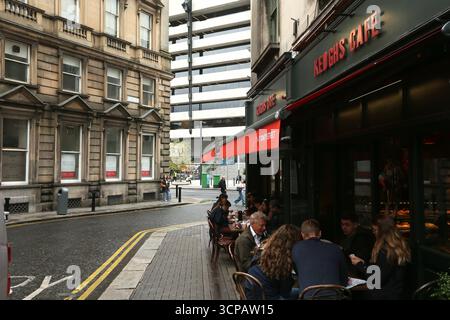 Dublin, Irlande - 19 septembre 2025 - Un café avec places assises à l'extérieur sur Trinity Street où les gens se détendent et dînent dans la ville de Dublin par un après-midi couvert humide dans la capitale irlandaise Banque D'Images