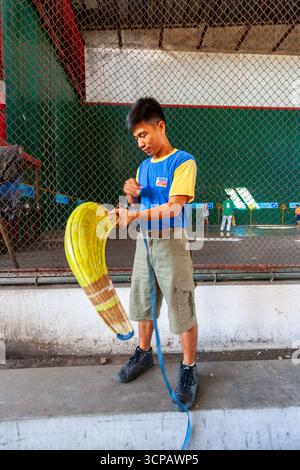 Un jeune pelotari philippin montrant comment enfiler sa cesta à un fronton Jai Alai à Cebu City, Philippines Banque D'Images