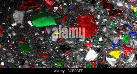 Vue détaillée de pièces de verre multicolores serties dans une base en béton poli foncé. Banque D'Images