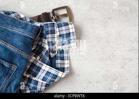 Messy casual Things jeans, chemise et ceinture sur une table, vue de dessus, espace pour le texte Banque D'Images