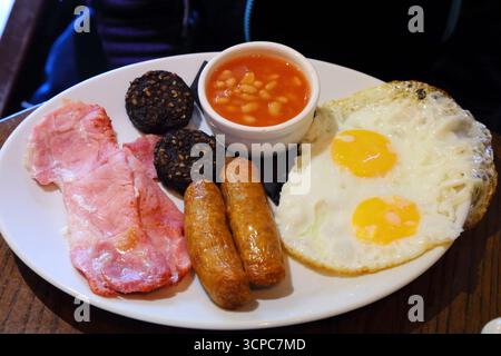 Petit déjeuner irlandais. Repas traditionnel du matin avec saucisse, bacon, pudding, oeuf frit et haricots. Banque D'Images