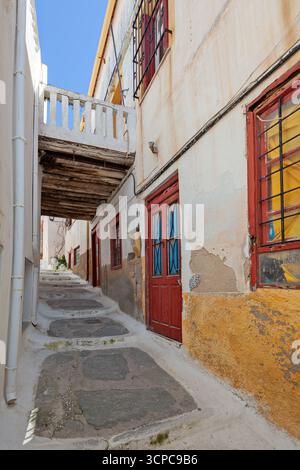 Étroite ruelle pavée de pierre avec des maisons rustiques colorées à Ioulida, île de Kea, Cyclades, Grèce. Banque D'Images