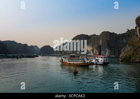 Cat Ba, Vietnam - 20 mars 2025 : bateaux de pêche traditionnels vietnamiens dans la baie de LAN Ha, Ha long. Magnifiques îlots karstiques calcaires, eau de mer turquoise. Banque D'Images