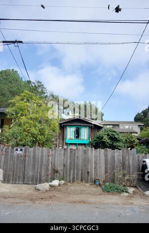 Cabine rustique avec volets turquoise et clôture de jardin Banque D'Images