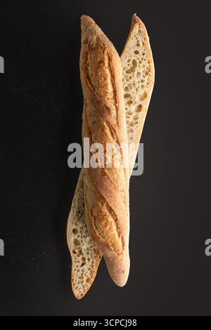 Tranches de baguette croustillantes sur fond foncé Fresh Bakery Sourdough Bread gros plan pour la photographie alimentaire Banque D'Images