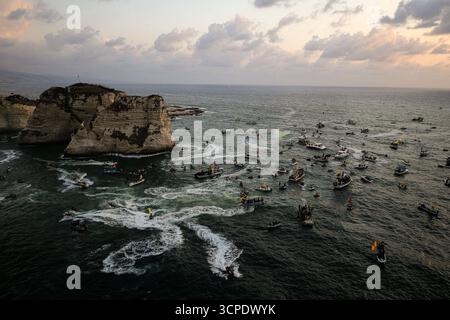 Beyrouth, Liban. 25 septembre 2025. Les partisans pro-iraniens du Hezbollah à bord de petits bateaux défilent près du·célèbre pigeon rocher du Liban au cours d'un événement marquant le premier anniversaire de l'assassinat du chef du parti Hassan Nasrallah dans une frappe aérienne israélienne massive. Crédit : Marwan Naamani/dpa/Alamy Live News Banque D'Images
