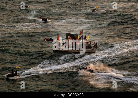 Beyrouth, Liban. 25 septembre 2025. Les partisans pro-iraniens du Hezbollah à bord de petits bateaux défilent près du·célèbre pigeon rocher du Liban au cours d'un événement marquant le premier anniversaire de l'assassinat du chef du parti Hassan Nasrallah dans une frappe aérienne israélienne massive. Crédit : Marwan Naamani/dpa/Alamy Live News Banque D'Images
