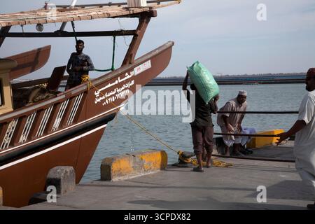 homme sur un boutre amarré au port au sultanat sur oman d'oman Banque D'Images