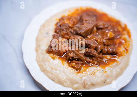 Nourriture traditionnelle turque Hunkar Begendi avec base de purée d'aubergines crémeuse. Fait avec de la viande tendre servie sur une assiette blanche. Concept de cuisine turque d'anatolie Banque D'Images