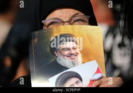 Beyrouth, Liban. 25 septembre 2025. Un partisan du Hezbollah tenant des portraits des anciens dirigeants du Hezbollah Hassan Nasrallah et Hashem Safieddine assiste à un rassemblement de masse dans la région de Raouche à Beyrouth, Liban, le 25 septembre 2025. Des centaines de partisans du Hezbollah se rassemblent jeudi sur le front de mer de Beyrouth pour commémorer les anciens dirigeants Hassan Nasrallah et Hashem Safieddine. Crédit : Bilal Jawich/Xinhua/Alamy Live News Banque D'Images