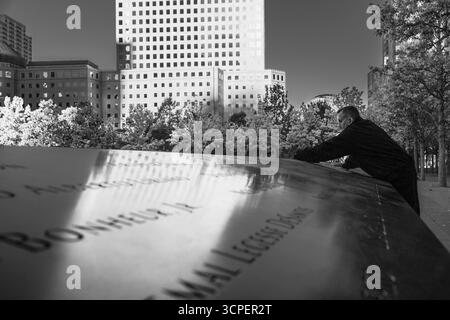 Homme nettoyant le marbre gravé du mémorial de 9-11, New York City, NY, États-Unis Banque D'Images