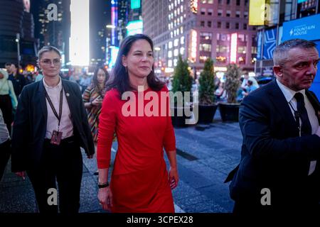 New York, États-Unis. 25 septembre 2025. Annalena Baerbock, présidente de l’Assemblée générale des Nations Unies, se promène avec des gardes du corps à Times Square dans la soirée pour une interview en marge du débat général de l’Assemblée générale des Nations Unies à New York. Plus de 140 chefs d'État et de gouvernement devraient assister au plus grand événement diplomatique au monde pendant plusieurs jours. Crédit : Kay Nietfeld/dpa/Alamy Live News Banque D'Images
