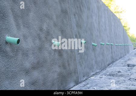 Une rangée de tuyaux verts dépasse d'un mur en béton armé sur un chantier de construction, Hermann Hessebahn construction site, Calw, Allemagne Banque D'Images