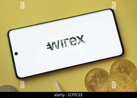 Dhaka, Bangladesh- 26 août 2025 : logo wirex sur l'écran du smartphone près de Bitcoin coin et QR code sur fond Banque D'Images