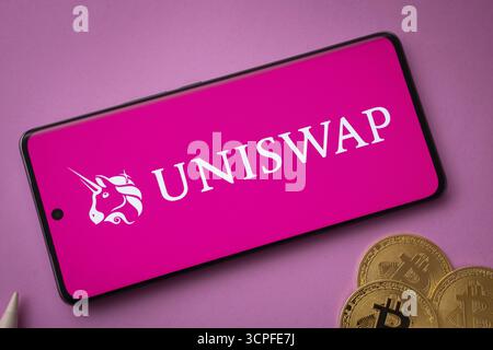 Dhaka, Bangladesh- 15 juin 2025 : logo Uniswap sur l'écran du smartphone près de Bitcoin coin et QR code sur fond Banque D'Images