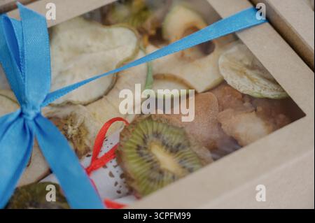 Coffret cadeau avec fruits secs et baies. Gros plan d'un paquet de fruits secs comprenant des tranches de kiwi, de pomme et de poire Banque D'Images